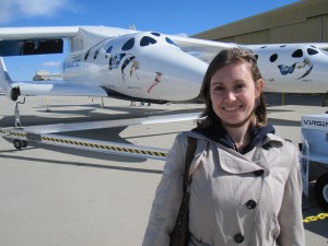 SpaceKate standing in front of Virgin Galactic's White Knight and Spaceship 2